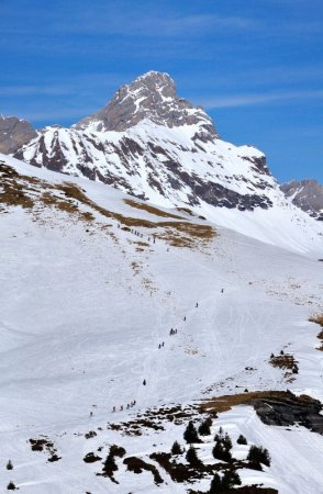 Procession de skieurs montant au «Grand» avec la pointe percée en fond