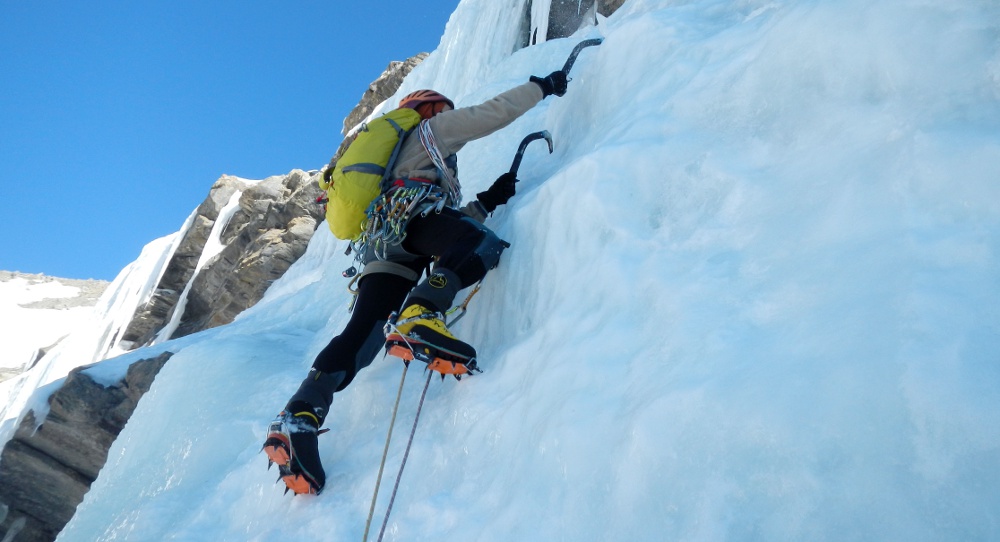 Pieds Du ` S D'alpiniste Avec Des Crampons Sur Le Glacier Congelé