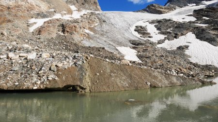 Petite moraine médiane du glacier : amas de roches et de glace plongeant dans le lac.