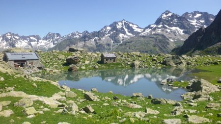 Refuge de Vallonpierre avec les montagnes en fond d’écran, qui reflètent dans le petit lac