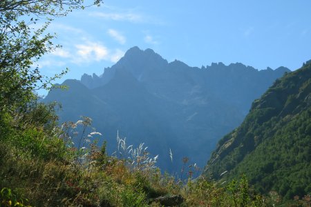 Vue à l’EST en contre-jour vers les plus hauts sommets du Massif des Écrins : Dôme de Neige des Écrins (4015m) à gauche et Pic Lory (4088m) à droite, qui masque la Barre des Écrins (4102m).