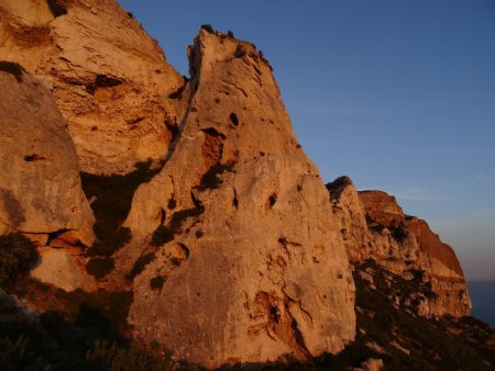La grotte des émigrés se trouve à gauche semblant être la bouche du rocher qui ressemble à une tête.